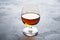 Alcoholic drink in a glass of Cognac brandy. Dark concrete background. Copy space