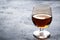 Alcoholic drink in a glass of Cognac brandy. Dark concrete background. Copy space