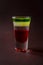 Alcoholic shot glass with grenadine, absent on elegant dark brow