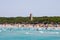 Alcudia pins tower and tourist swimming in Playa de Muro beach, Alcudia