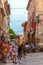 ALCUDIA, SPAIN - July 8, 2019: Restaurant tables on street with tourists in seaside Alcudia old town, Mallorca island