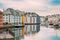 Alesund, Norway. Young Woman Tourist Traveler Photographer Taking Pictures Photos Of Old Wooden Houses In Cloudy Summer