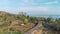 Alex Drone shot of small road with bridge in african coastline. Beautiful landscape with tall palm trees and rooftops of