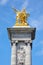Alexandre III bridge golden statue with winged horse and column in a sunny day, blue sky in Paris