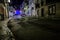 Alfama neighbourhood at night. Long exposure shot of riding car on the street in Lisbon. Illuminated street of old european town