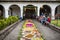 Alfombre, flower carpet for Semana Santa in church backyard and local people sitting along, Santiago Atitlan, Guatemala