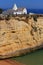 Algarve, Portugal. Typical historical chapel with whitewashed walls against a blue sky.