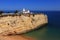 Algarve, Portugal. Typical historical chapel with whitewashed walls against a blue sky.