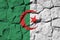 Algeria flag depicted in paint colors on old stone wall closeup. Textured banner on rock wall background