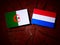 Algerian flag with Dutch flag on a tree stump isolated