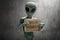 Alien creature hold cardboard sign