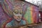 alien street artist creates intricate and colorful piece of art on brick wall