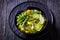 Alkaline green soup in black bowl, top view