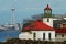 Alki Point Lighthouse by the sea with the background of the cityscape in Seattle, Washington, USA