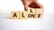 All or alone and support symbol. Businessman turns the wooden cube and changes the word alone to all. Beautiful white background.