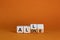 All or alone and support symbol. Turned the wooden cube and changed the word alone to all. Beautiful orange background. Business