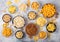 All classic potato snacks with peanuts, popcorn and onion rings and salted pretzels in bowl plates on light background. Twirls