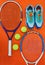 It all comes as a package. High angle shot of tennis essentials placed on top of an orange background inside of a studio