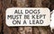 All Dogs Must Be Kept On Lead sign - sign on tree