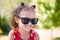 All a girl really needs is a little sunshine. an adorable little girl wearing sunglasses while at the park.