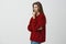 We all have secrets in closets. Portrait of romantic sensual european woman in loose red sweater, standing in profile