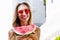 All Inclusive Cheap Summer Holidays. Young Happy Woman with Watermelon and pink sunglasses at beach Background. Summertime fun