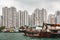 All kind of boats in front of tall buildings in harbor of Hong Kong, China