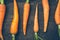 All-natural carrots lined up on wooden board