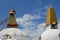 All-seeing Eyes of Buddha overseeing Boudhanath, while a worker applies paint on a stupa\\\'s spire, Kathmandu