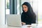 All set for productivity. Portrait of a young muslim businesswoman using a laptop at her work desk.