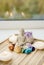 All seven chakra colors crystals stones around sitting Buddha figurine on natural wooden tray.