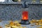 All Souls\\\' Day. A lit candle on the grave. Background with cemetery. Soulstice - remembrance of the dead - Halloween.