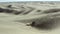 All terrain vehicle ATV driving over sand dunes in desert, aerial view