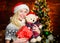 All she wants for christmas. Cheerful woman. Woman got teddy bear toy present. Santa hat christmas accessory. Cute gift