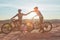 All you need are wheels and willpower. Full length shot of two young male athletes fist bumping while mountain biking in