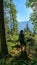 Allakogel - Hiker woman on hiking trail in dense alpine forest with scenic view of majestic mountains of Hochschwab