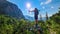 Allakogel - Hiker woman on hiking trail in dense alpine forest with scenic view of majestic mountains of Hochschwab