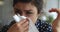 Allergic ill indian woman holding handkerchief blowing running nose