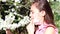 Allergy season. A young girl in a medical mask sniffs Apple blossoms