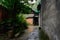 Alley between aged dwelling buildings after rain