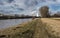 The alley on the banks of the river Elbe with a background factory