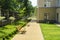 Alley with lawns, benches, trees and a metal fence