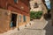 Alley with old building and boy next to open door at Caceres