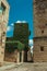 Alley with old stone buildings, one of them covered by creepers at Caceres