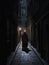 An alleyway shrouded in midnight black a robed figure hunched nearby. Gothic art. AI generation