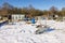 Allotment garden with wheelbarrow in winter covered with snow