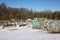 Allotment garden with wheelbarrow in winter covered with snow