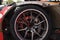 Alloy wheel with calipers and racing brakes of the sport car. Racing brake disc and low profile tyres. Race car test driving.