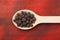 Allspice berries on wooden spoon