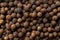 Allspice jamaica pepper texture background. Dried brown berries of the Pimenta dioica tree. Concepts of organic spices, seasonings